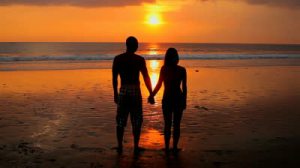couple-holding-hands-on-the-beach-in-the-sunset